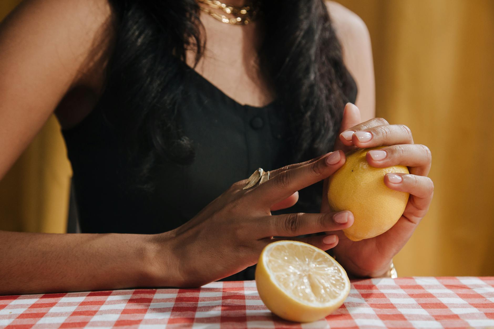 Two hands holding silicone clitoral vibrators against a soft pastel background