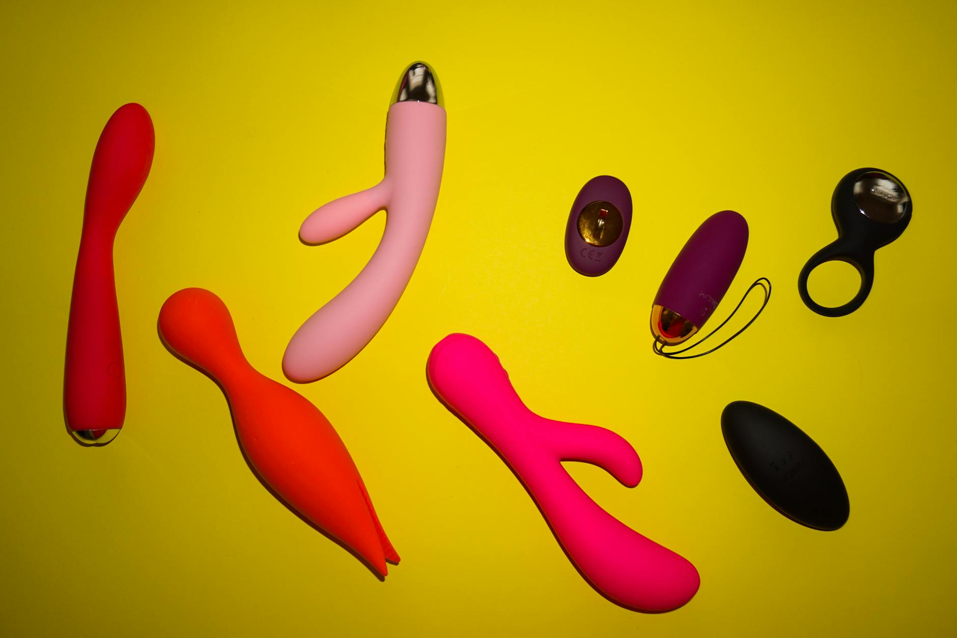 Colorful adult toys and vibrators arranged on a bright surface, symbolizing diverse pleasure options and reconnection